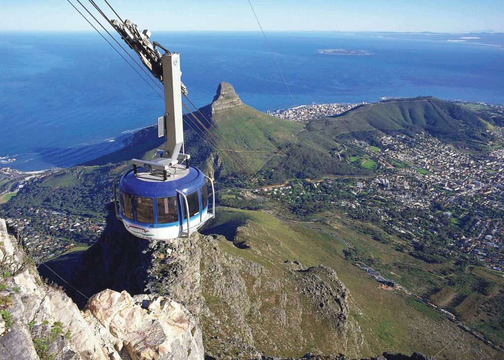 Image from the mountaintop looking down on the city with a large cable car in the foreground